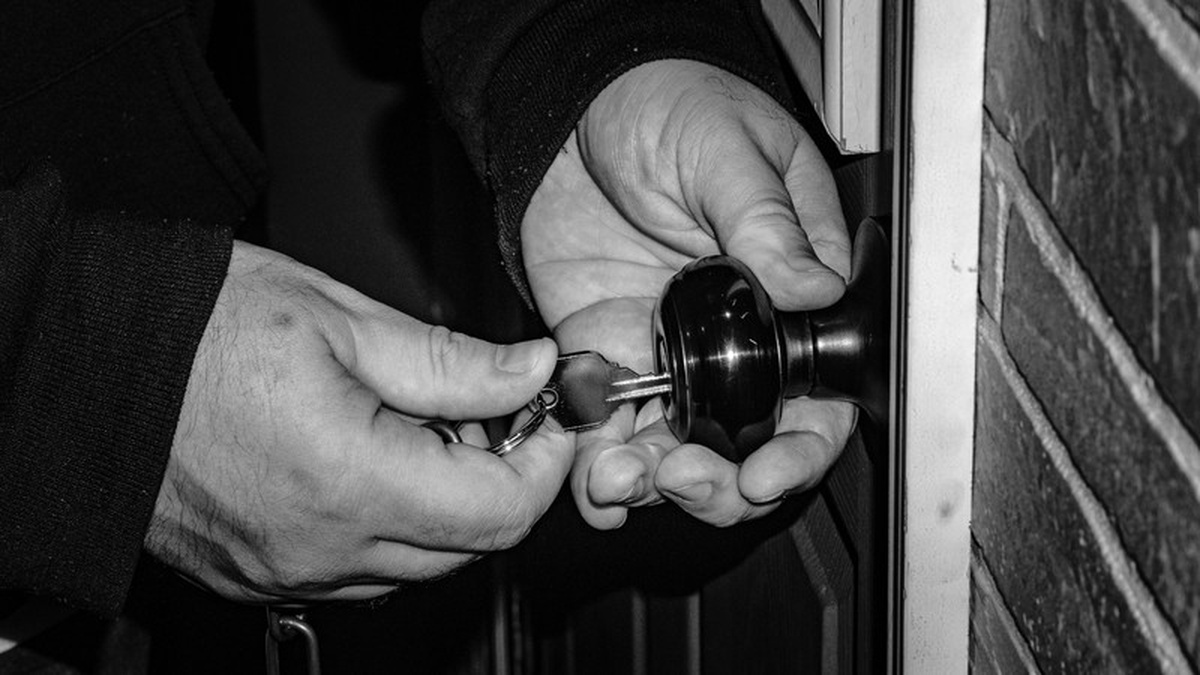 Hände mit Schlüssel an einem Türschloss