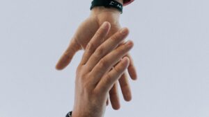 Zwei Hände, die sich berühren und Unterstützung symbolisieren.